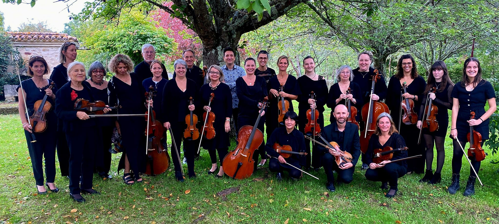 Jonathan Raspiengeas entouré d'un rassemblement joyeux de musiciens posant ensemble, y compris des violonistes présentant leurs instruments.