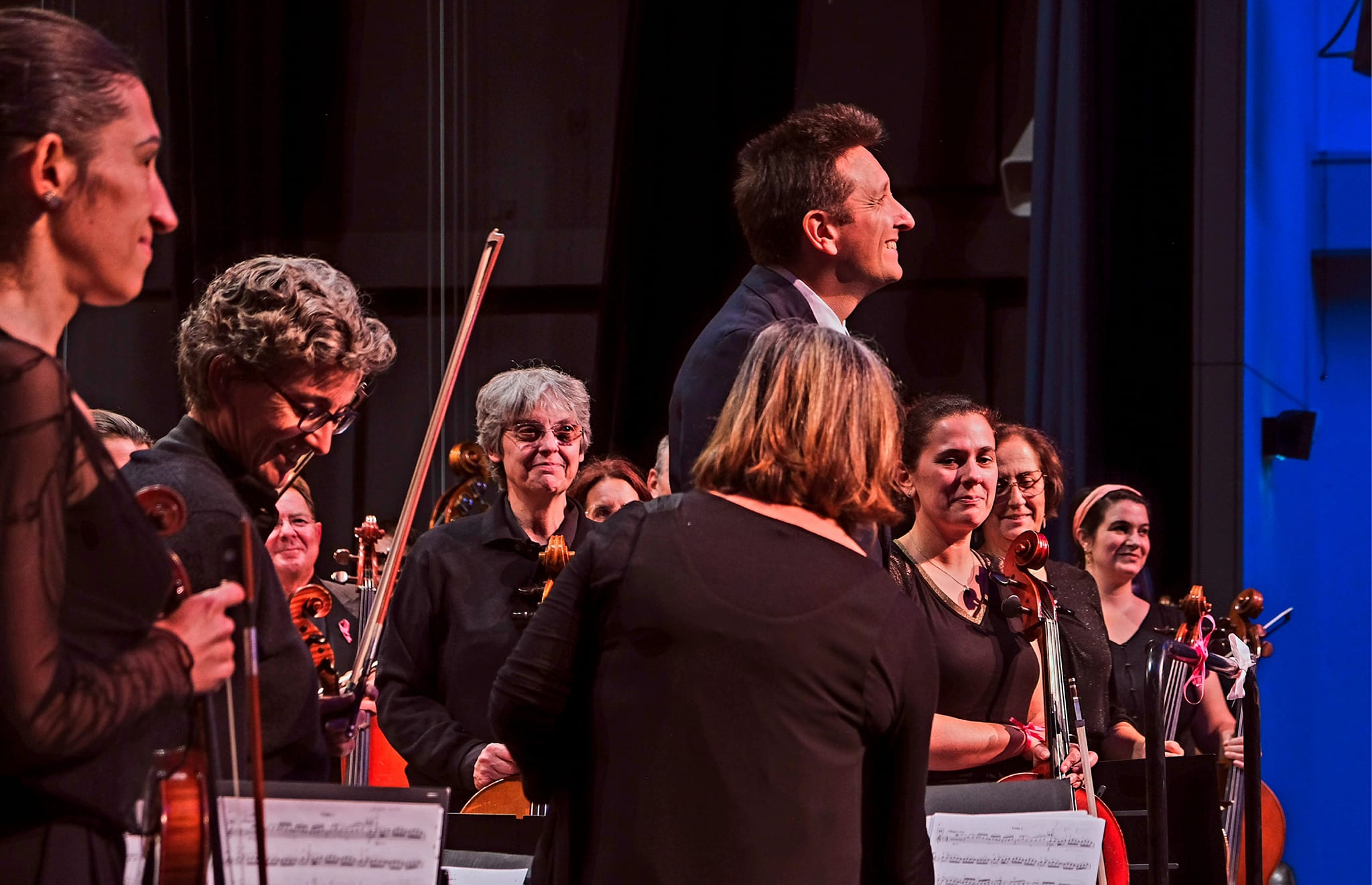 Jonathan Raspiengeas dirige un orchestre qui l'observe attentivement, engagé dans l'expérience musicale.